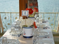 στα τραπέζια σουπλά και βάζα με λουλούδια διακοσμημένα με ναυτικό θέμα