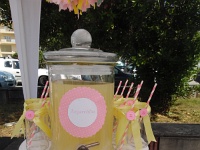 βάζα λεμονάδας διακοσμημένα με κίτρινες κορδέλες και ροζ κουμπί
