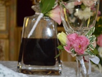 το ποτήρι του κρασιού διακοσμημένο με τριαντάφυλλο και ροζ λυσίανθο