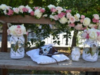 στο παγκάκι διακόσμηση με παιόνιες, τριαντάφυλλα, λυσίανθο και vintage φωτογραφική μηχανή επάνω σε πλεκτό μαξιλάρι