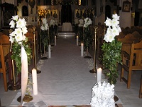 εσωτερικός διάδρομος εκκλησίας με κατασκευές απο λευκές αμαρυλλίδες, φυλλώματα και κισσό πάνω σε μπρούτζινη βάση